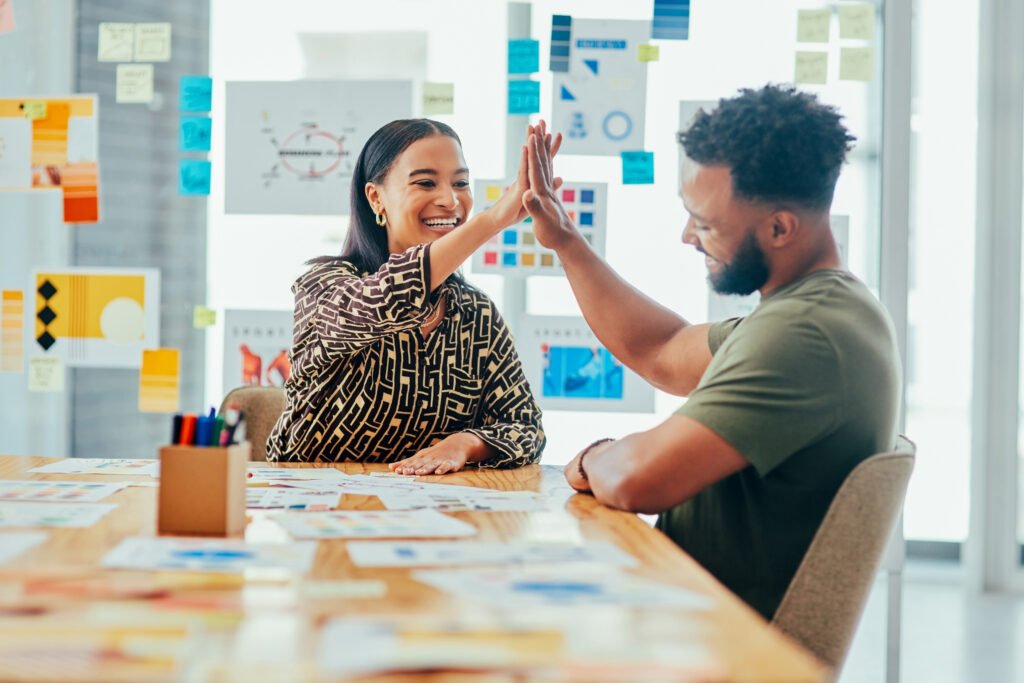 Shot of two young designers giving each other a high five while working together in an office